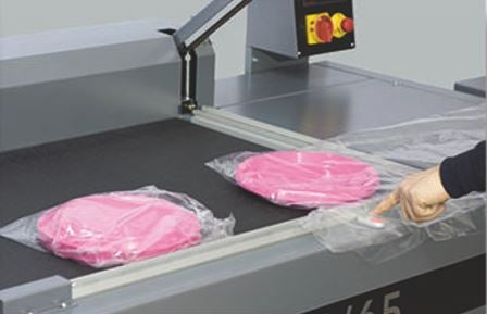 Operator placing products in film on the Maripak LMC-P 14065P sealing table